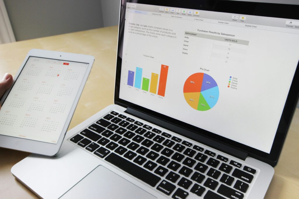 Data analyst con una tablet en la mano con calendario y notebook con información estadística.